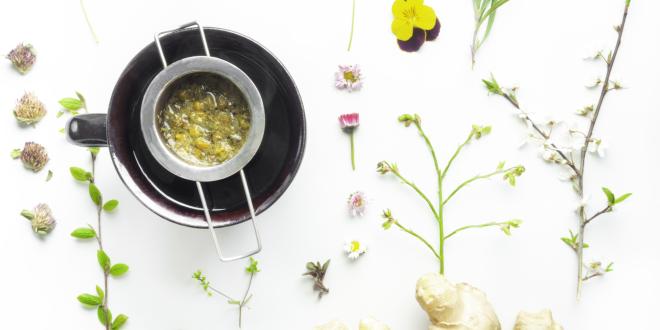 Tea cup with a diffuser over it filled with chopped ginger.