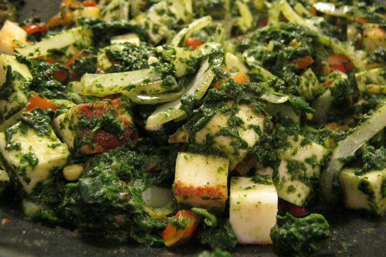 a pan of spinach and cooking cheese